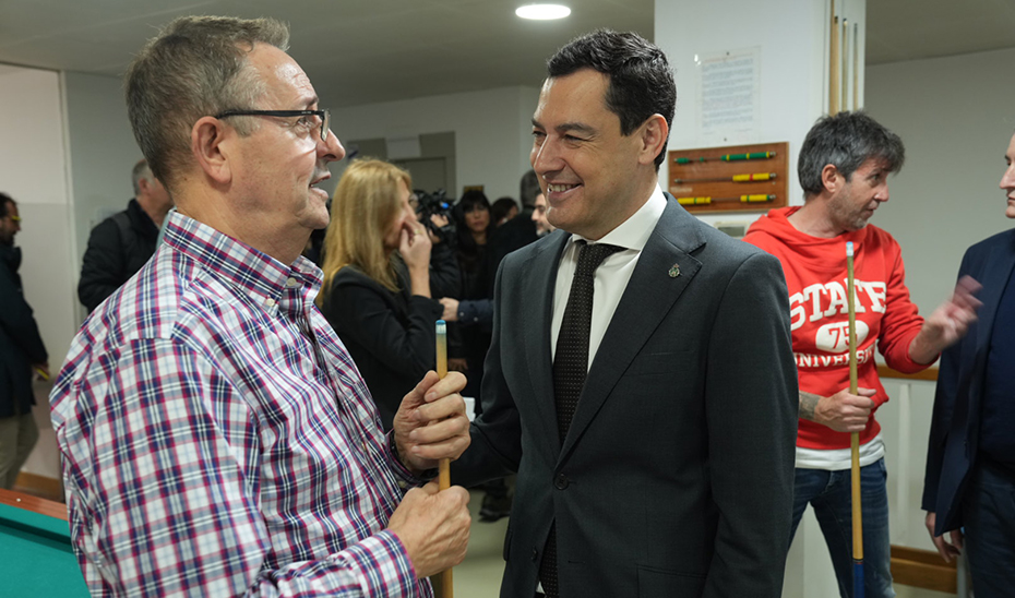 Juanma Moreno conversa con uno de los vecinos asistentes a la presentación de la nueva red Vuela.